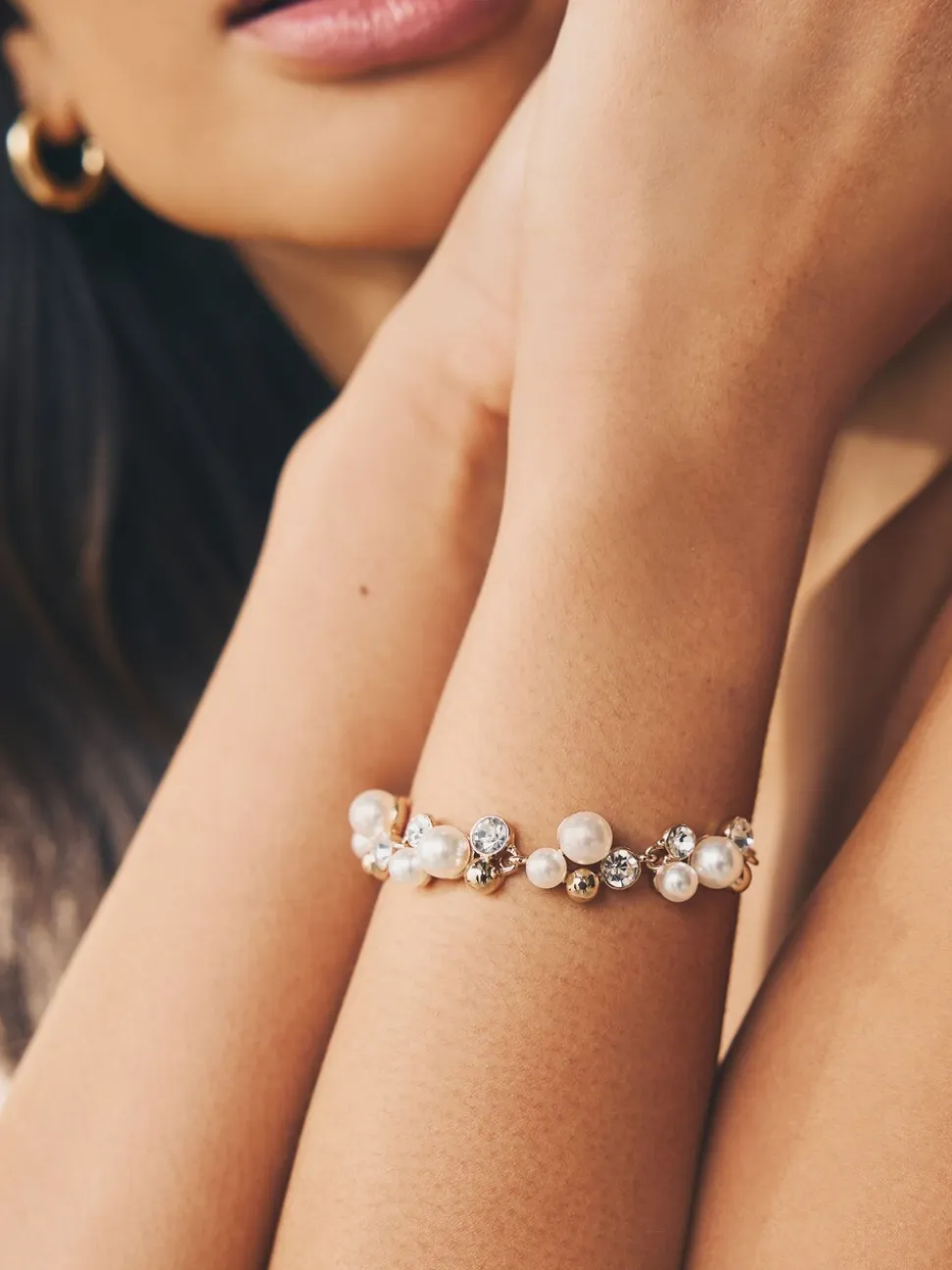 Goudkleurig - Doorgetrokken armband met pareleffect en glitters