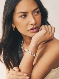 Goudkleurig - Doorgetrokken armband met pareleffect en glitters