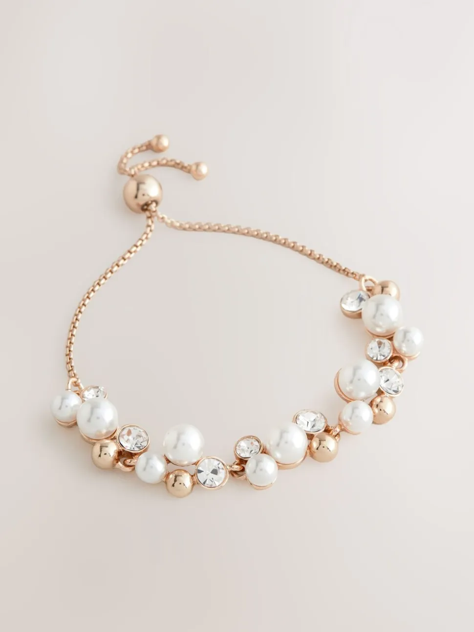 Goudkleurig - Doorgetrokken armband met pareleffect en glitters