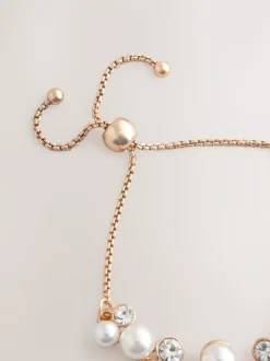 Goudkleurig - Doorgetrokken armband met pareleffect en glitters