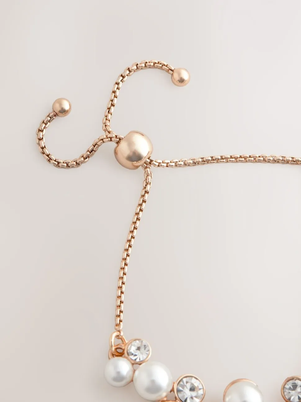 Goudkleurig - Doorgetrokken armband met pareleffect en glitters