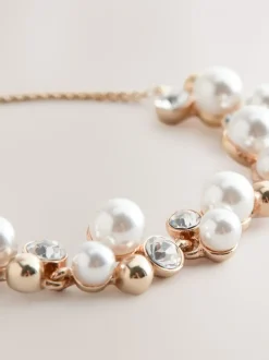 Goudkleurig - Doorgetrokken armband met pareleffect en glitters