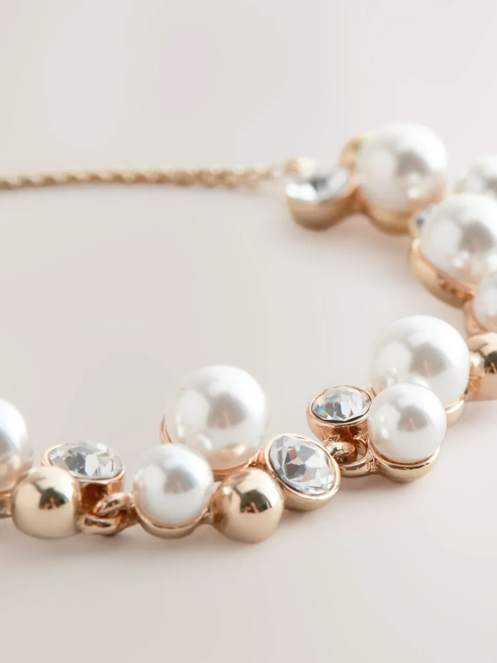 Goudkleurig - Doorgetrokken armband met pareleffect en glitters
