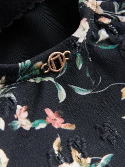 Zwart met broderie en fijne print - Badpak met vormgevende zijrimpeling en buikcorrectie